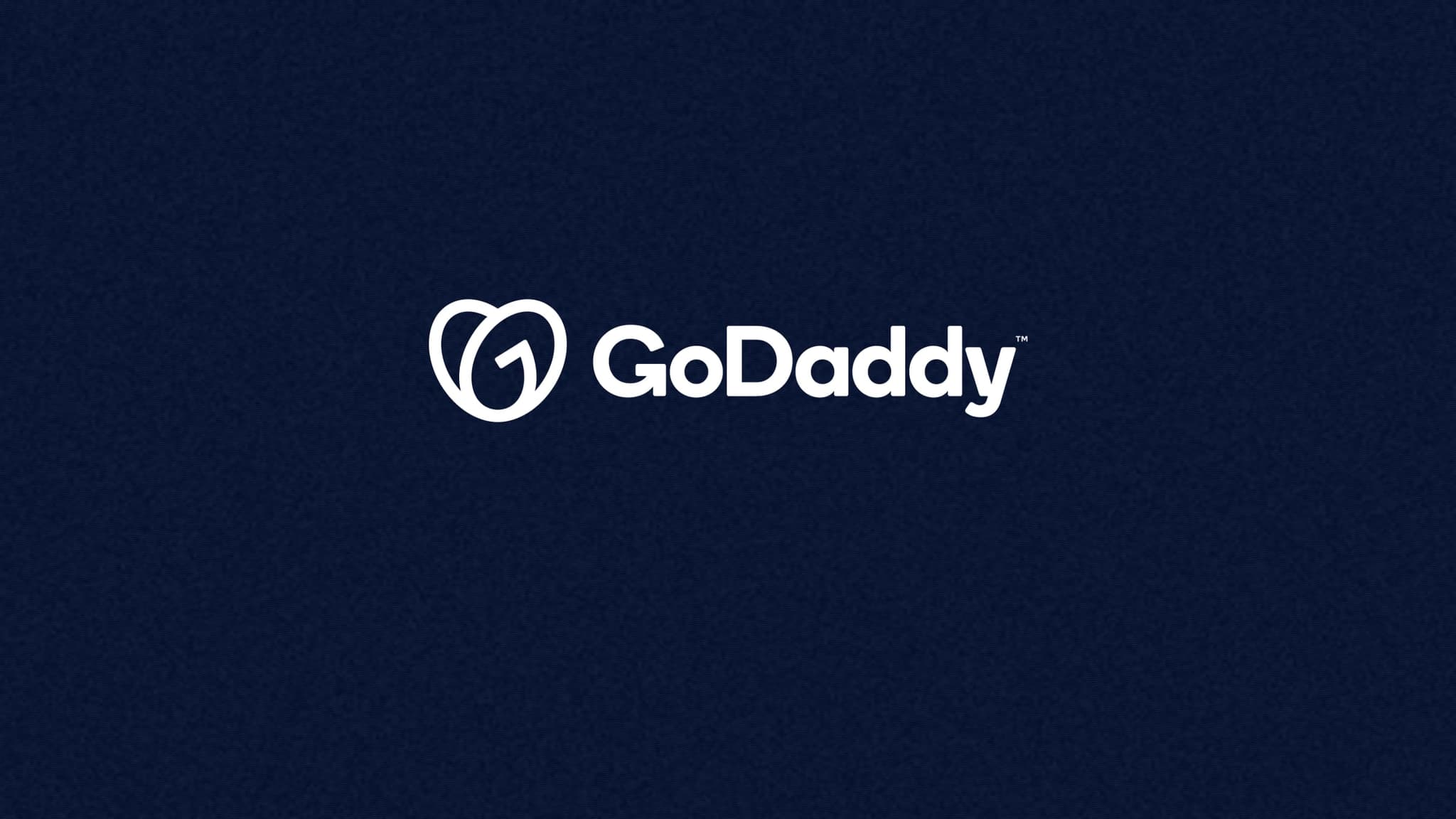 The GoDaddy logo, in the white version the company uses on its own newsroom, on a navy field. Photo illustration: SaasBuzz; logo: GoDaddy